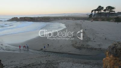 Visitors walk along the beach at sunset, time lapse
