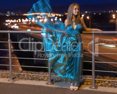 young beauty girl in fluttering blue dress outdoor