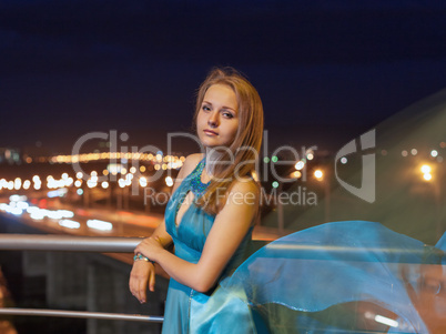 young beauty girl in fluttering blue dress outdoor
