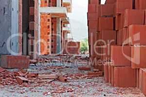 Stack of red building blocks on messy site