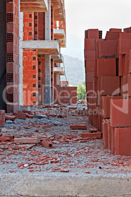 Stack of red building blocks on messy site