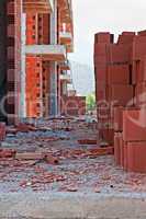 Stack of red building blocks on messy site