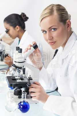 Female Scientist Research Team Using Microscopes in Laboratory