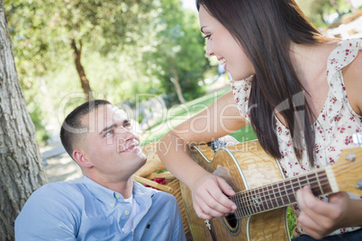 Mixed Race Couple at the Park Playing Guitar and Singing