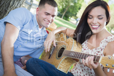 Mixed Race Couple at the Park Playing Guitar and Singing