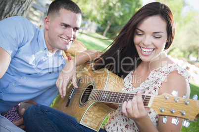 Mixed Race Couple at the Park Playing Guitar and Singing