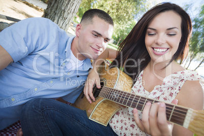 Mixed Race Couple at the Park Playing Guitar and Singing