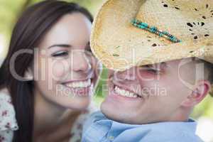 Mixed Race Romantic Couple with Cowboy Hat Flirting in Park