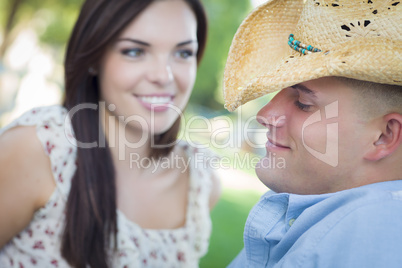 Mixed Race Romantic Couple with Cowboy Hat Flirting in Park