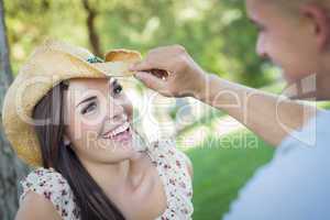 Mixed Race Romantic Couple with Cowboy Hat Flirting in Park