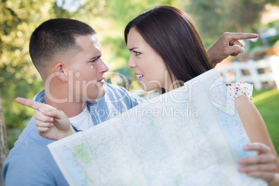 Confused Mixed Race Couple Looking Over Map Outside