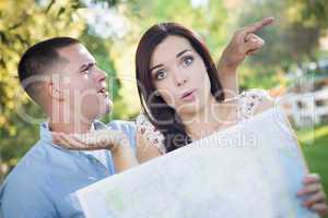 Lost and Confused Mixed Race Couple Looking Over Map Outside