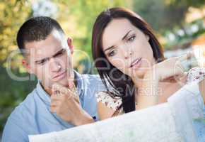 Lost and Confused Mixed Race Couple Looking Over Map Outside