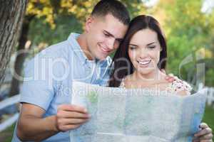 Mixed Race Couple Looking Over Map Outside Together