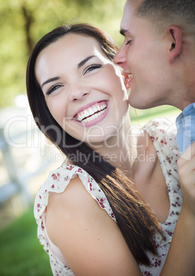 Mixed Race Romantic Couple Whispering in the Park