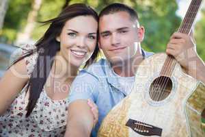 Mixed Race Couple Portrait with Guitar in Park
