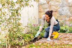 Young woman planting backyard flowerbed autumn