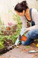 Woman kneeling planting flowerbed autumn garden