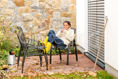 Happy woman relaxing autumn patio drinking tea