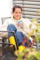 Happy woman relaxing cup tea sitting backyard
