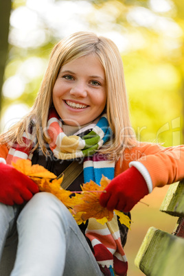 Autumn cheerful young girl sitting park fall