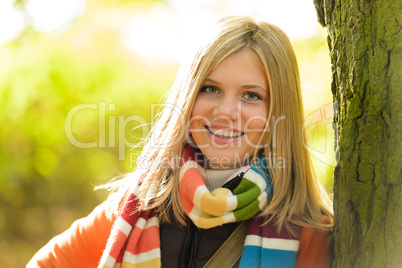 Smiling teenager blonde girl woods tree autumn