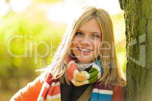 Smiling teenager blonde girl woods tree autumn