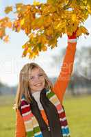 Carefree teen girl picking leaves fall playing