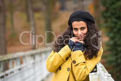 Young woman standing autumn park yellow coat