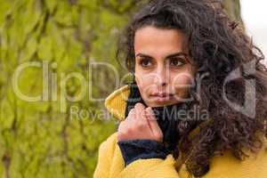 Woman looking forest coat with tree trunk
