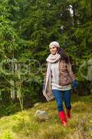 Happy woman walking in autumn forest