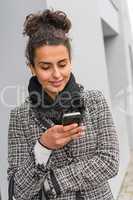 Happy woman sending text message on smartphone