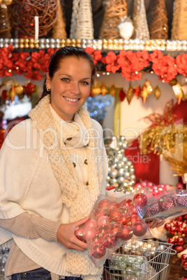 Cheerful woman buying Xmas decoration at shop