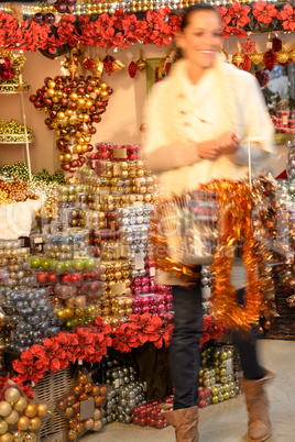 Smiling woman buying Christmas ornaments in shop