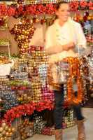 Smiling woman buying Christmas ornaments in shop