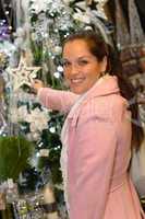 Young woman shopping Christmas decorations in coat