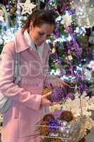 Happy woman buying sparkling Christmas decorations