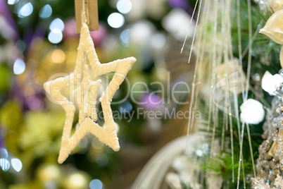 Gold star ornament hanging from Christmas tree