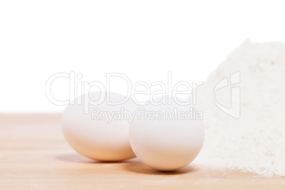 nahaufnahme von weissen eiern neben mehl