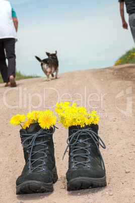 Front hiking boots and in the background people with dog