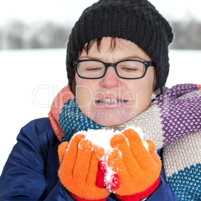 Woman holding snow in their hands