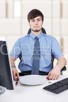 Young businessman sitting in front of empty plate in the office