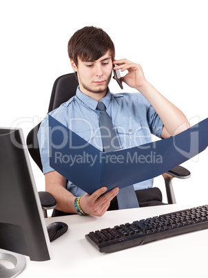 Young businessman examining contract with the phone in the office