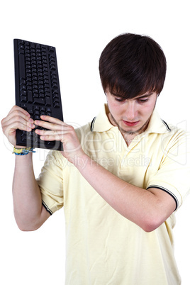 Young man smashes keyboard