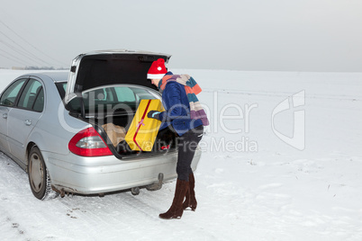 Woman standing by the open trunk and invites gift