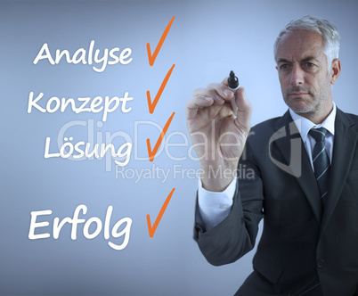 Attractive businessman writing a success checklist in german