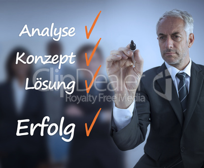 Businessman writing a success checklist in german