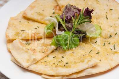 garlic pita bread pizza with salad on top