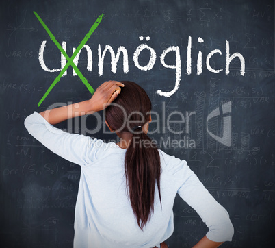 Attractive woman looking at a chalkboard with success in german