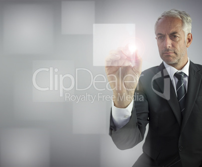 Serious businessman touching empty pane on digital screen